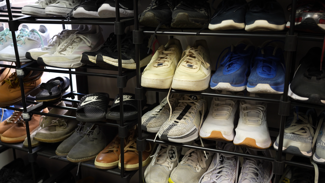 men's tennis shoes displayed on four sets of shelves